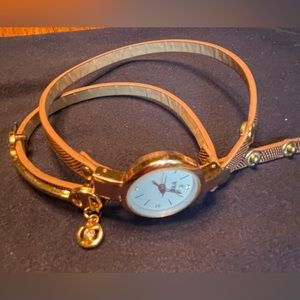 Wrap around wrist watch in rose gold hardware.